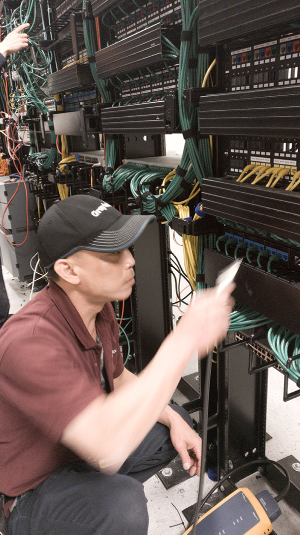 A man working on some wires in an office.