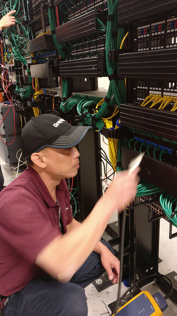 A man working on some wires in an office.