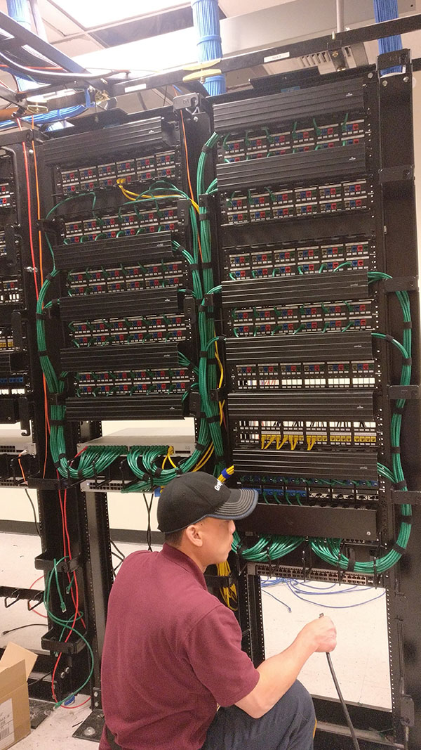 A man in a hat is looking at the wires.