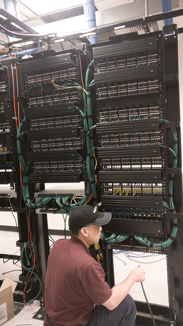 A man in a hat is looking at some wires.