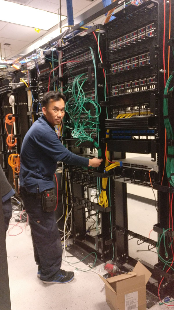 A man working on some wires in an office.