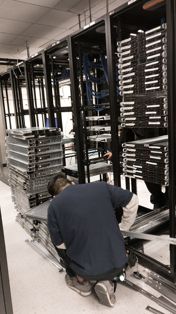 A man working in front of racks with metal parts.