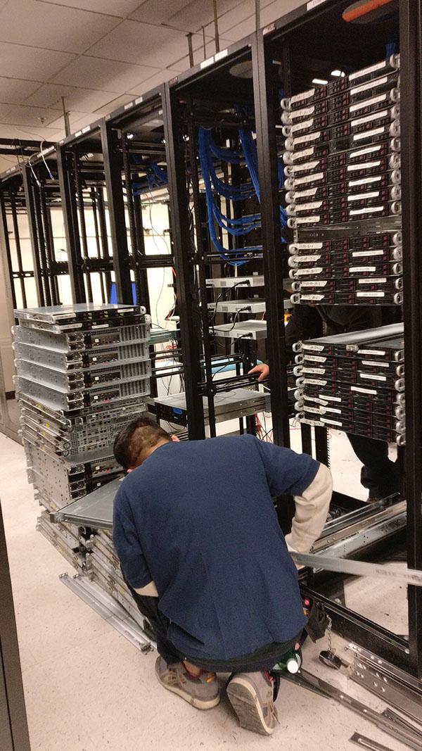 A man working in an industrial setting with racks of metal.