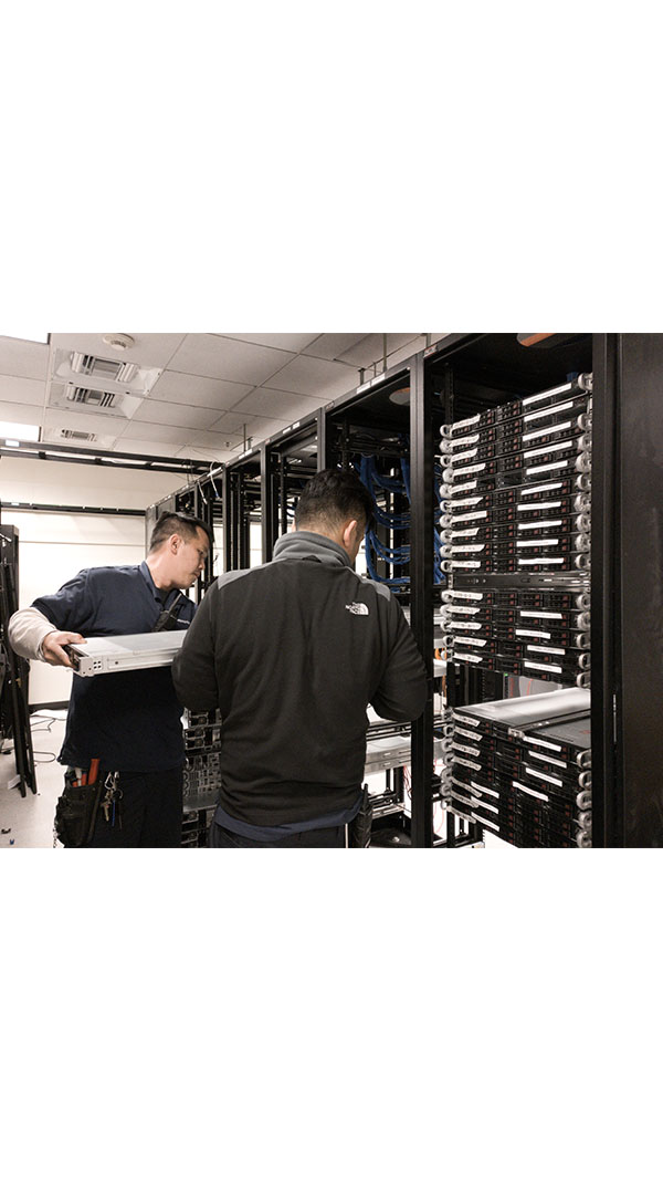 Two men working in a room with servers.