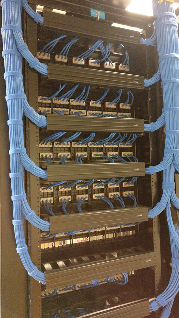 A bunch of wires hanging from the side of a wall.