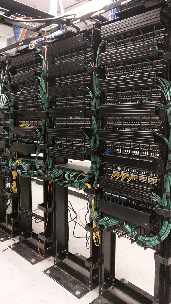 A large rack of wires and switches in a room.