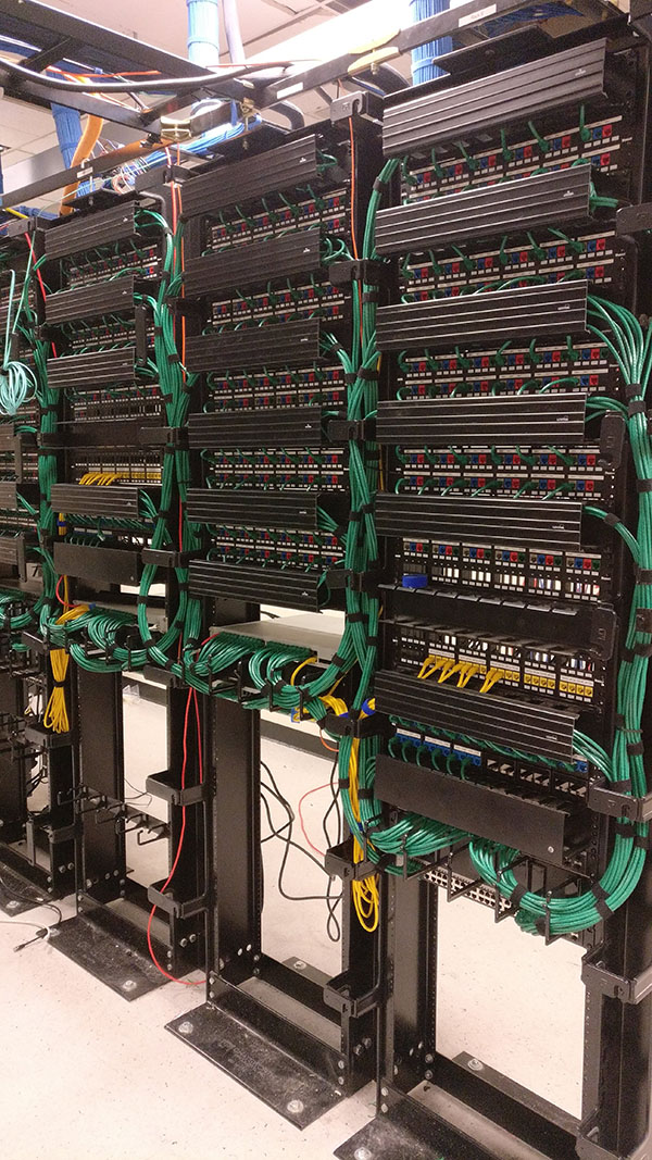 A bunch of wires hanging on the side of a wall.