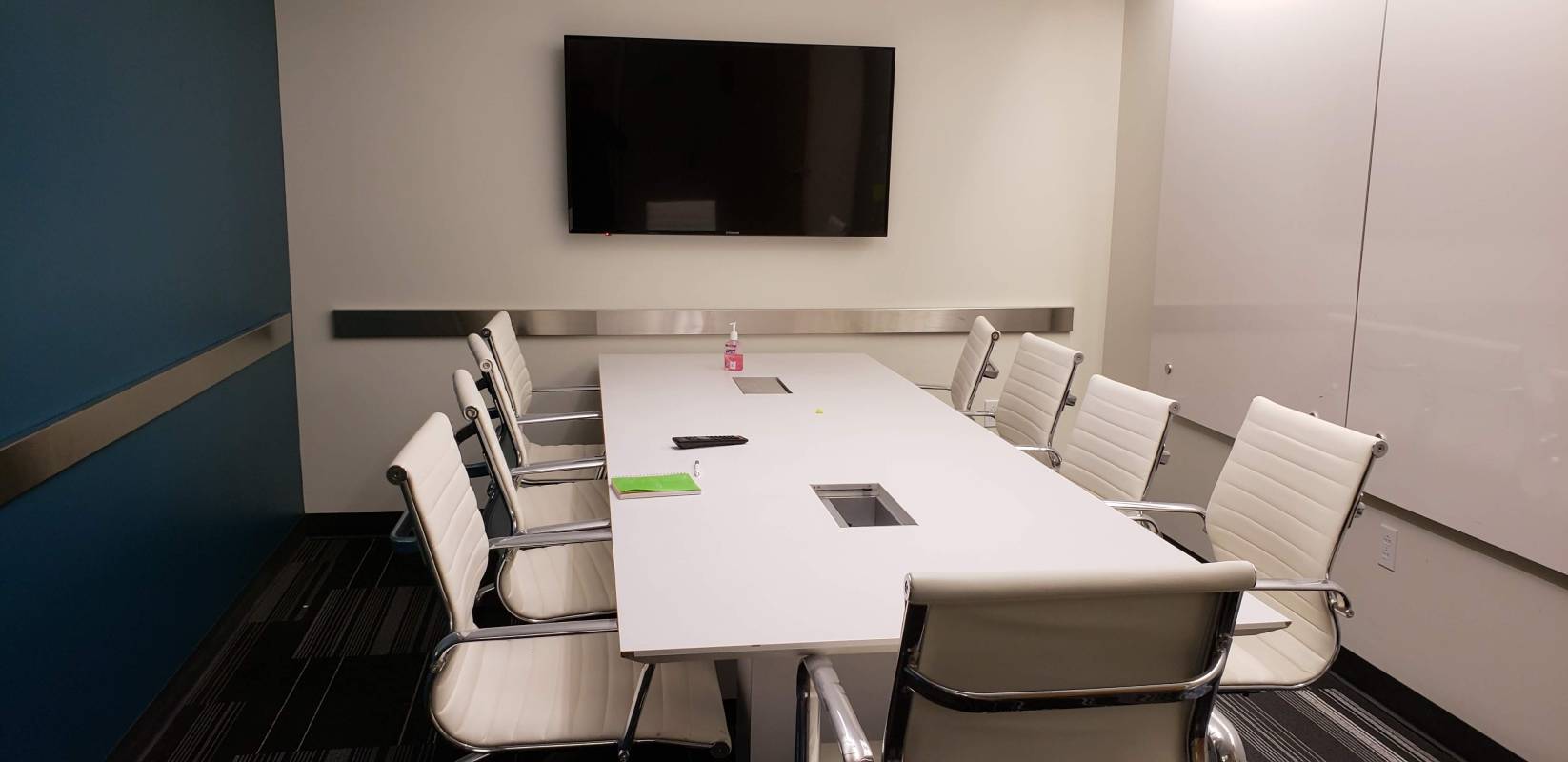 A conference room with white chairs and a table.