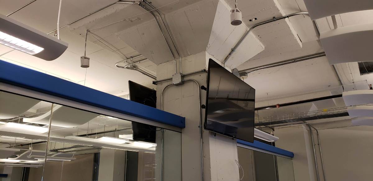 A tv mounted on the wall in an office building.