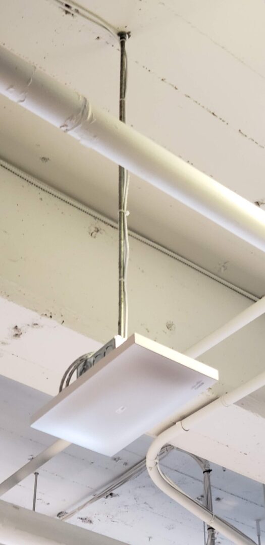A white ceiling with wires hanging from it.
