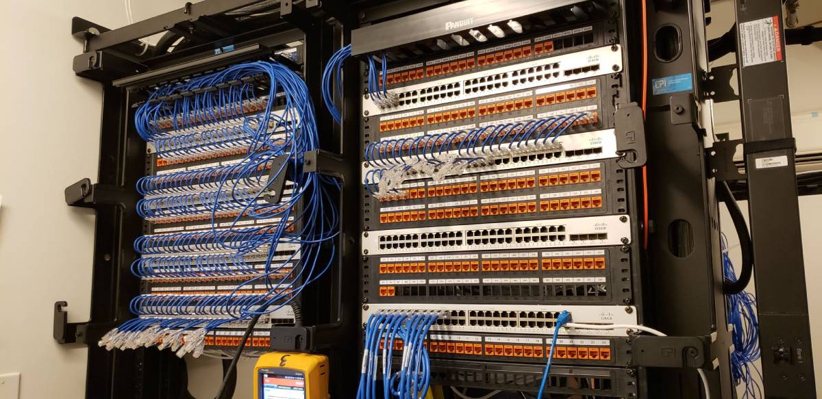 A large rack of wires and boxes in an electrical room.