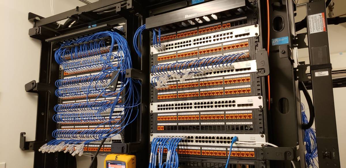 A large rack of wires and boxes in front of it.