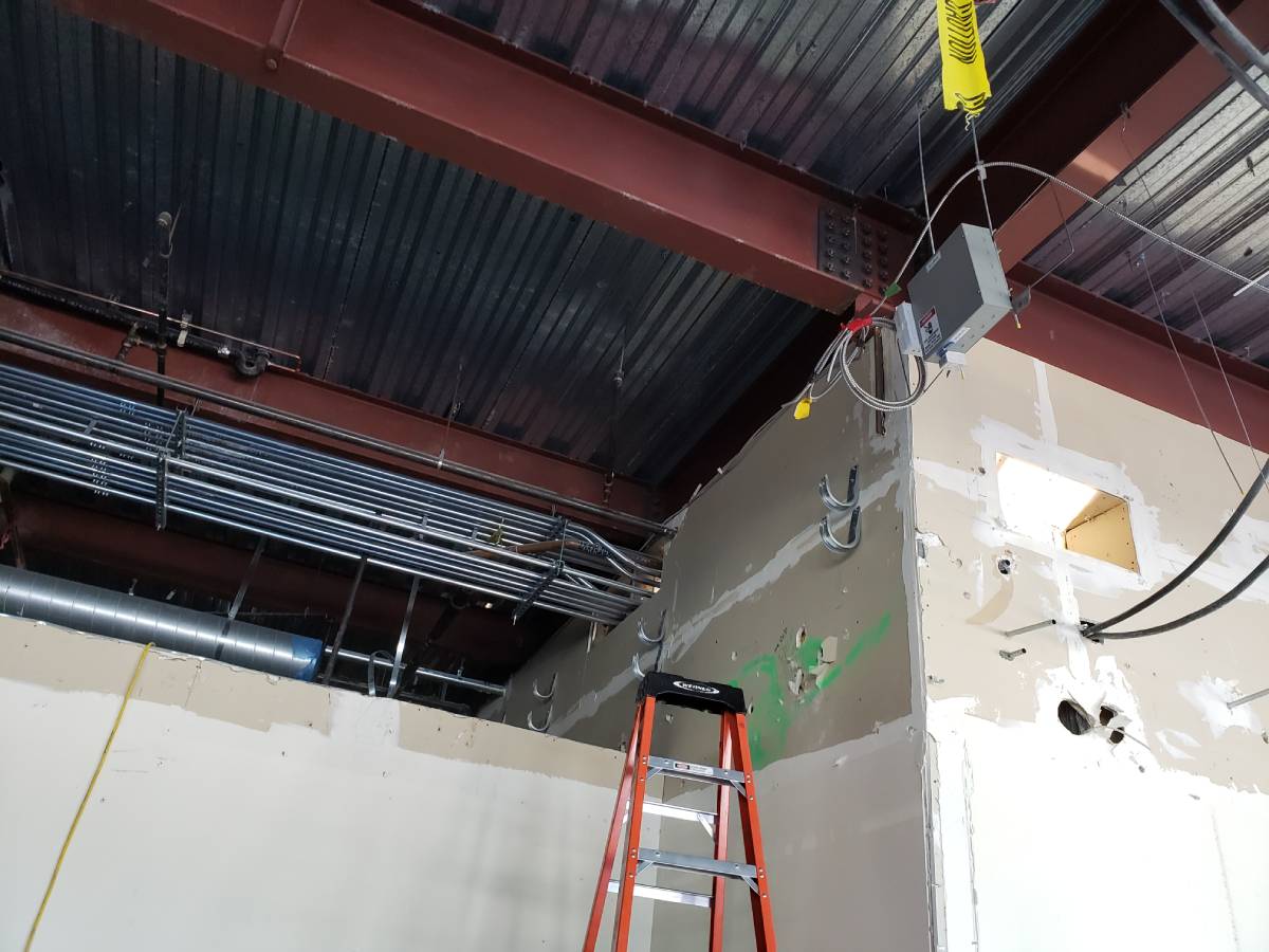 A ladder and some wires hanging from the ceiling.