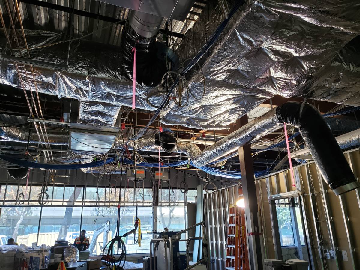 A room with many pipes and wires hanging from the ceiling.