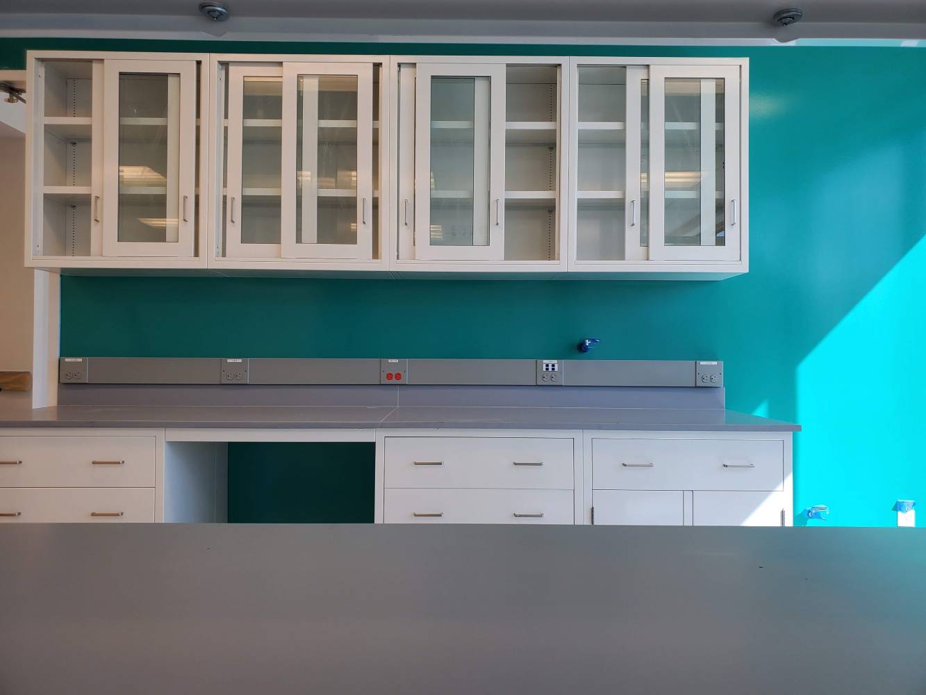 A kitchen with white cabinets and blue walls.