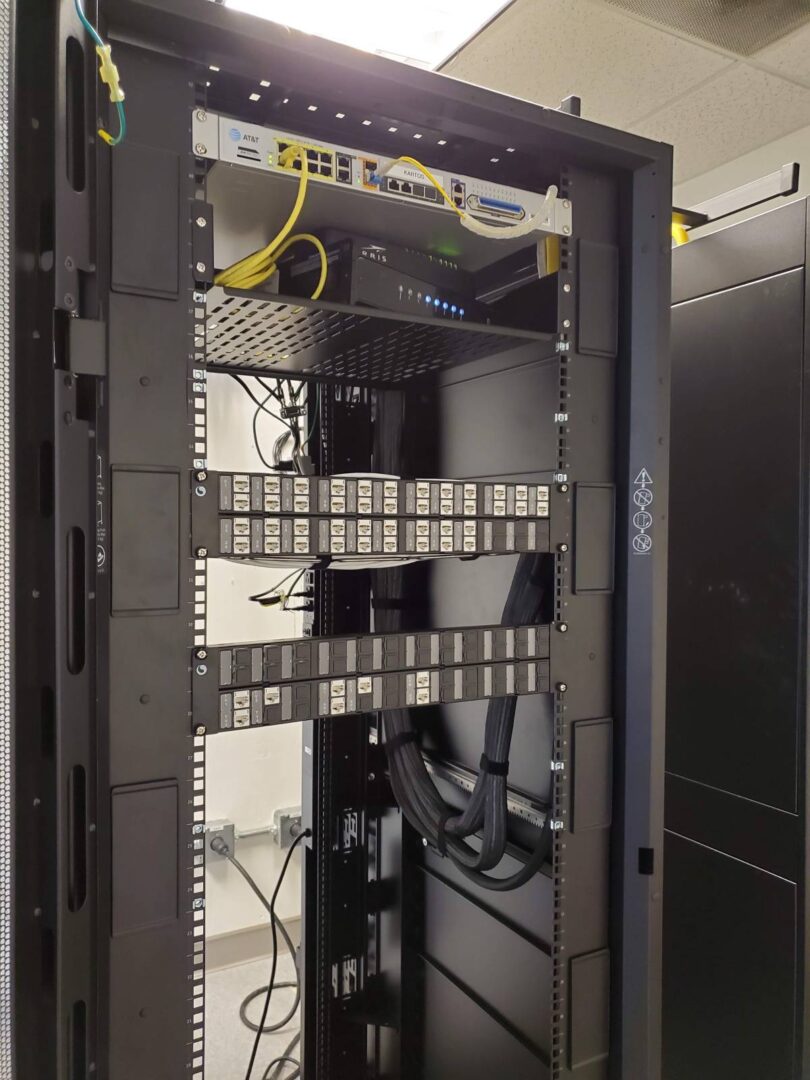 A rack with many wires and boxes in it