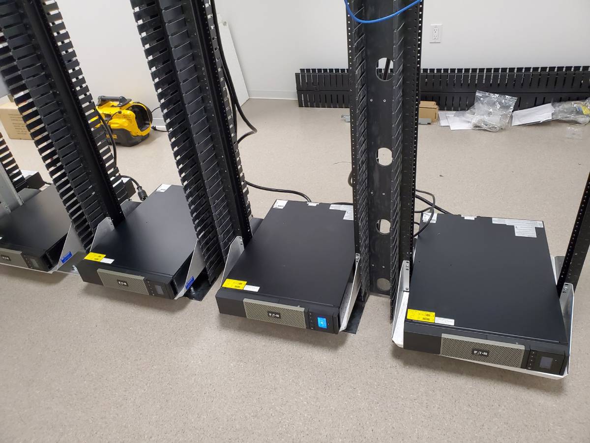 A group of black computer equipment sitting on top of a table.